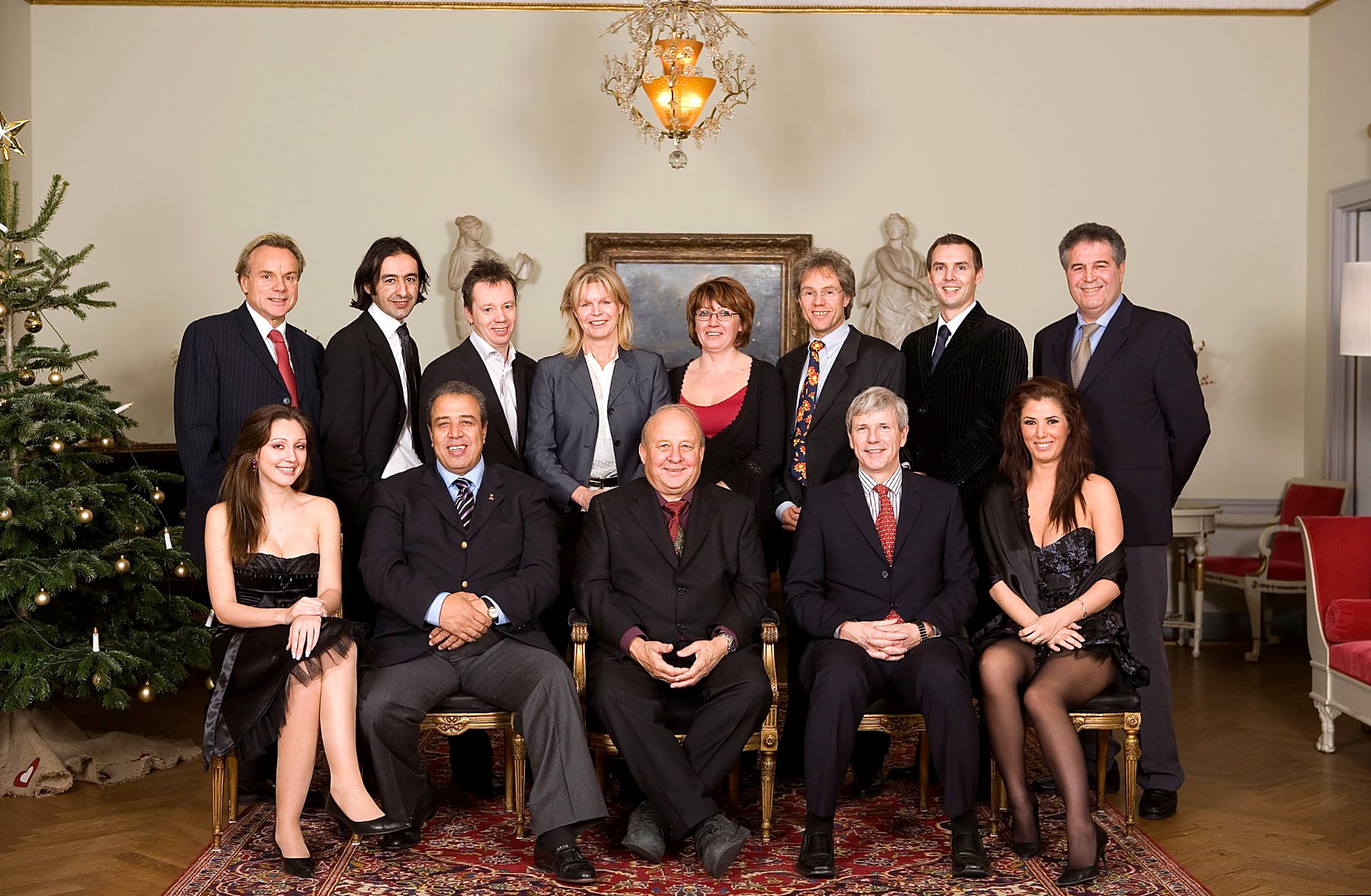 Gruppbild av kollegor i festkläder i en klassisk salong